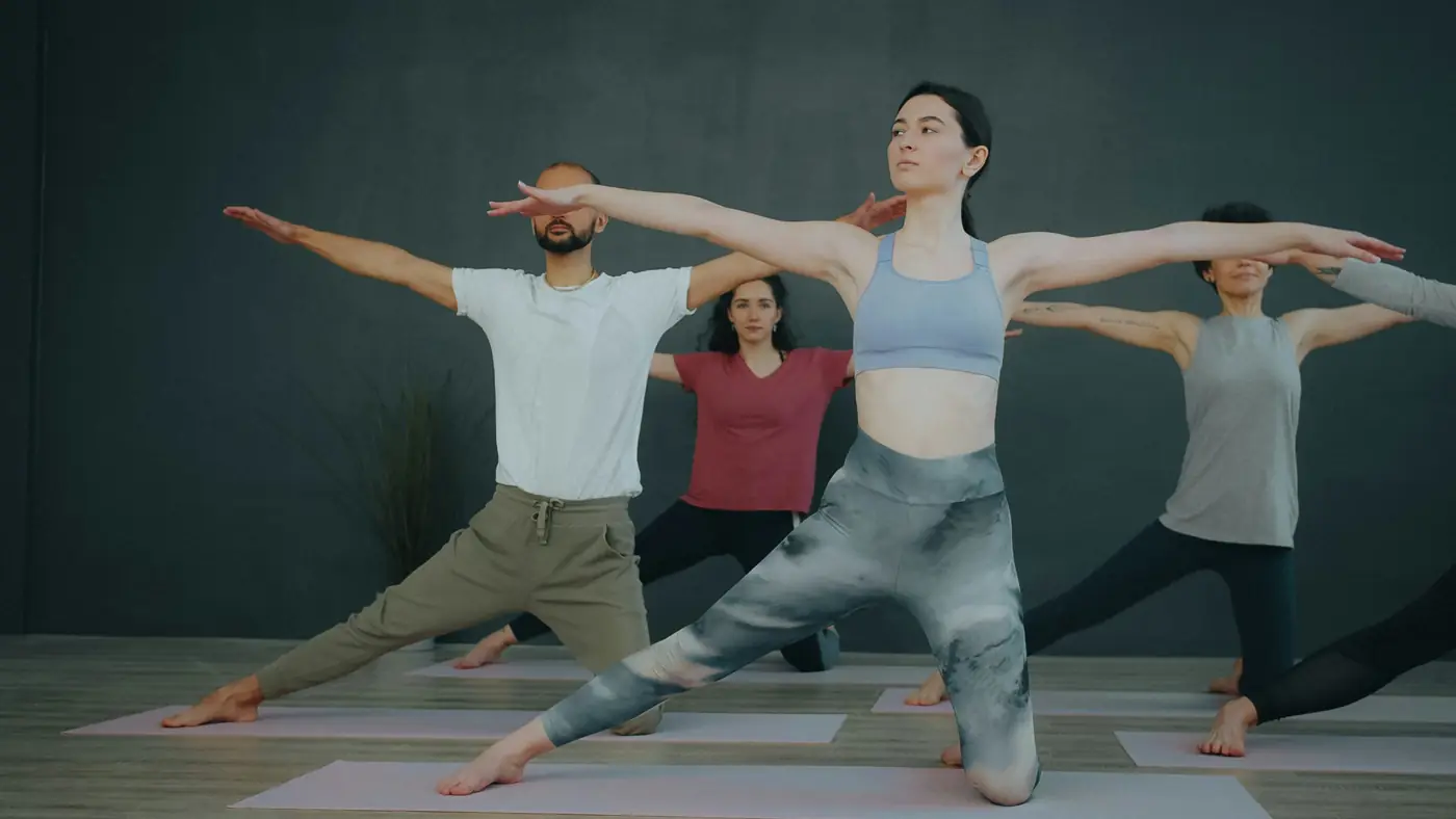 A group class stretching on mats in a studio